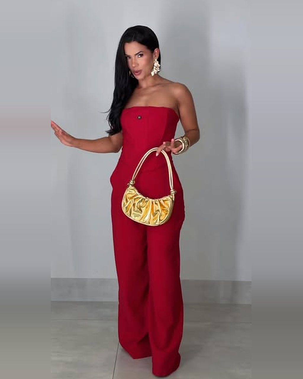Macacão pantalona vermelho tomara que caia com bolsa dourada