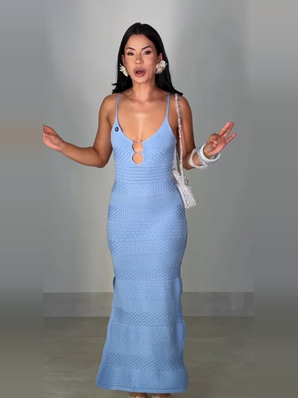 Vestido longo de tricô azul-claro com decote vazado e bolsa branca